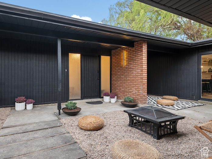 Entrance to property featuring brick siding and a patio area