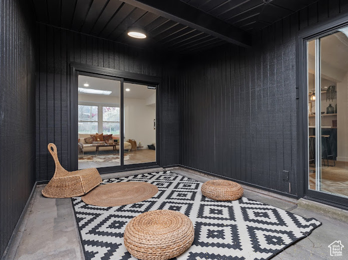 Living area featuring wood walls and concrete flooring