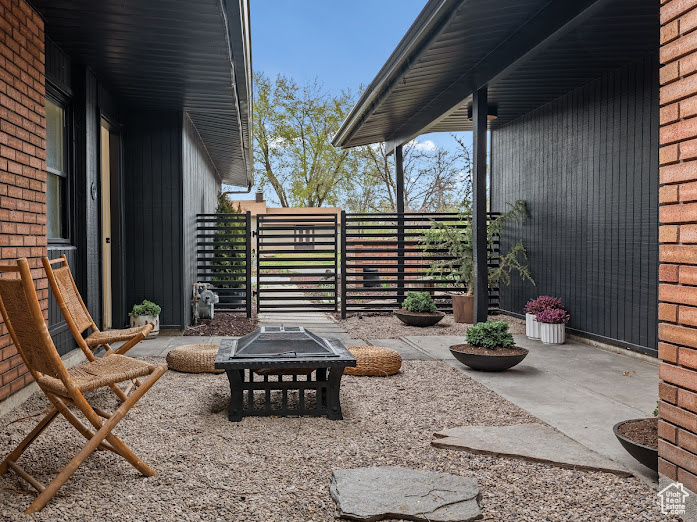 View of patio with fence and an outdoor fire pit
