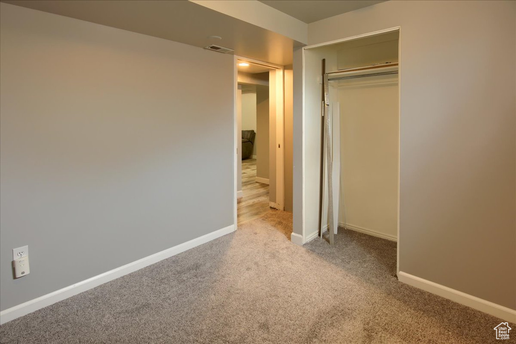 Unfurnished bedroom with baseboards, a closet, visible vents, and carpet