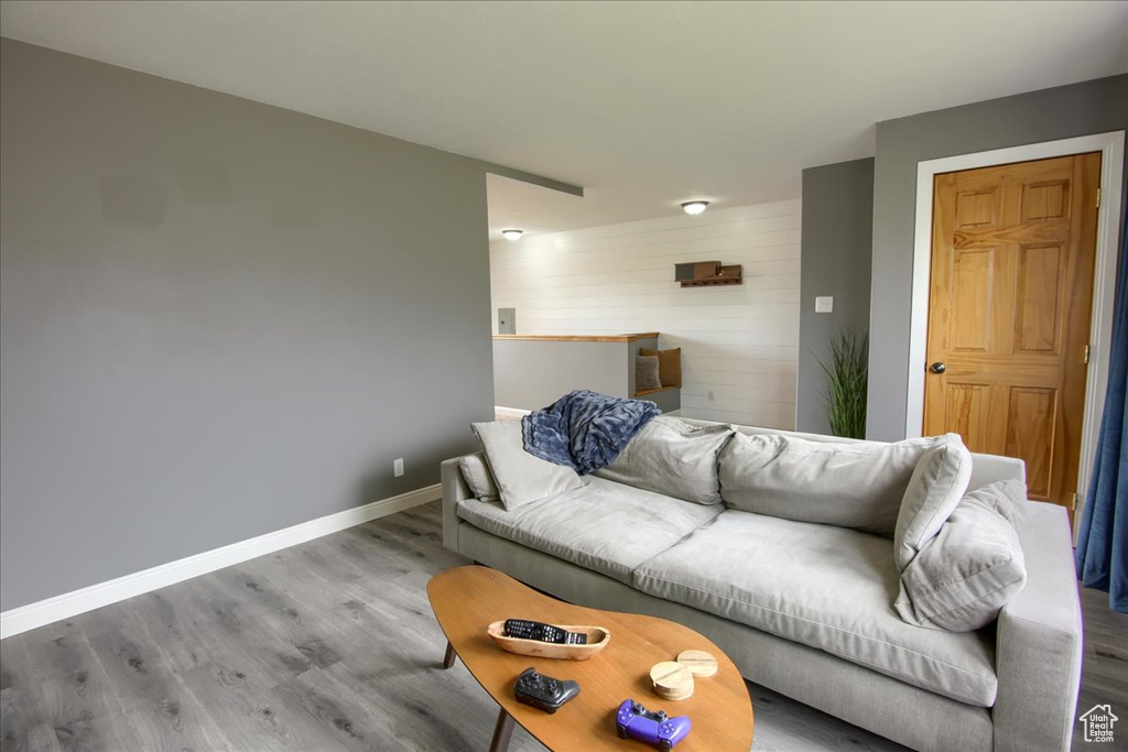 Living area featuring wooden walls, wood finished floors, and baseboards