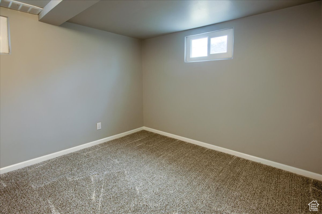 Basement with carpet, visible vents, and baseboards