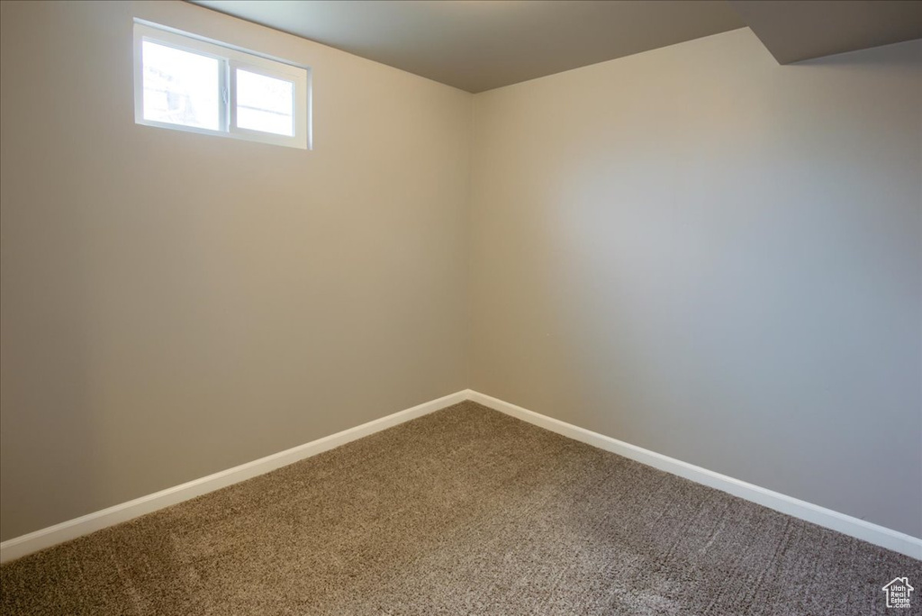 Carpeted empty room with baseboards