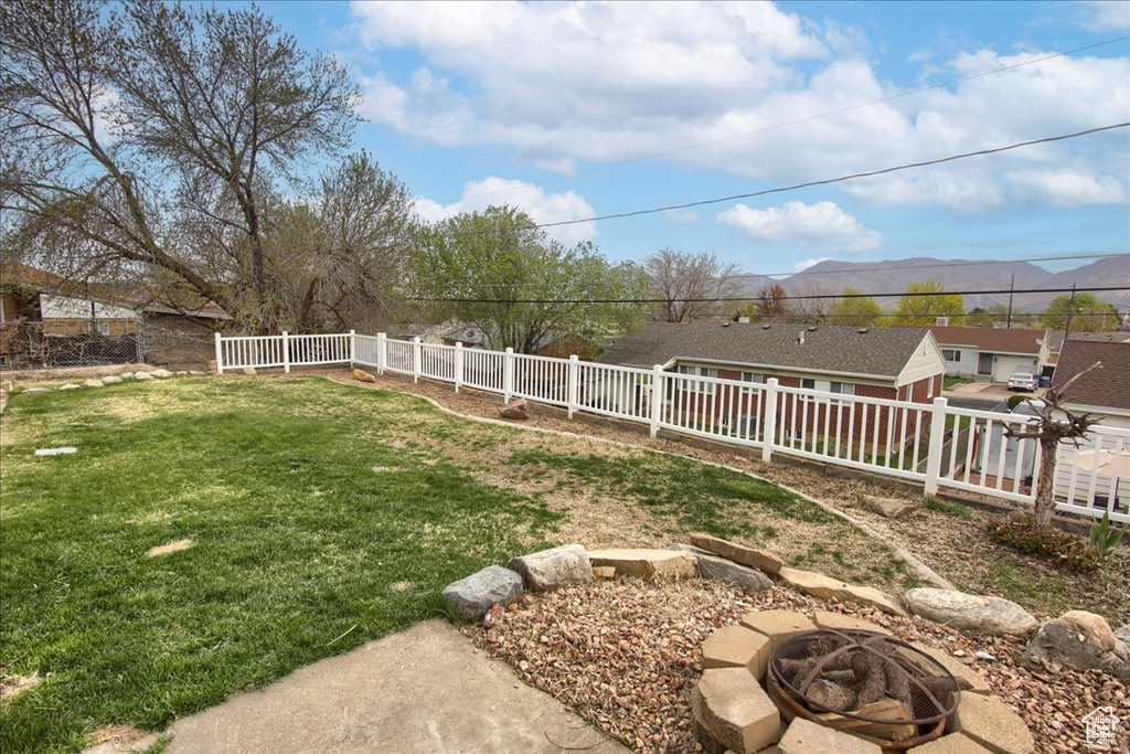 View of yard with a fenced backyard and an outdoor fire pit