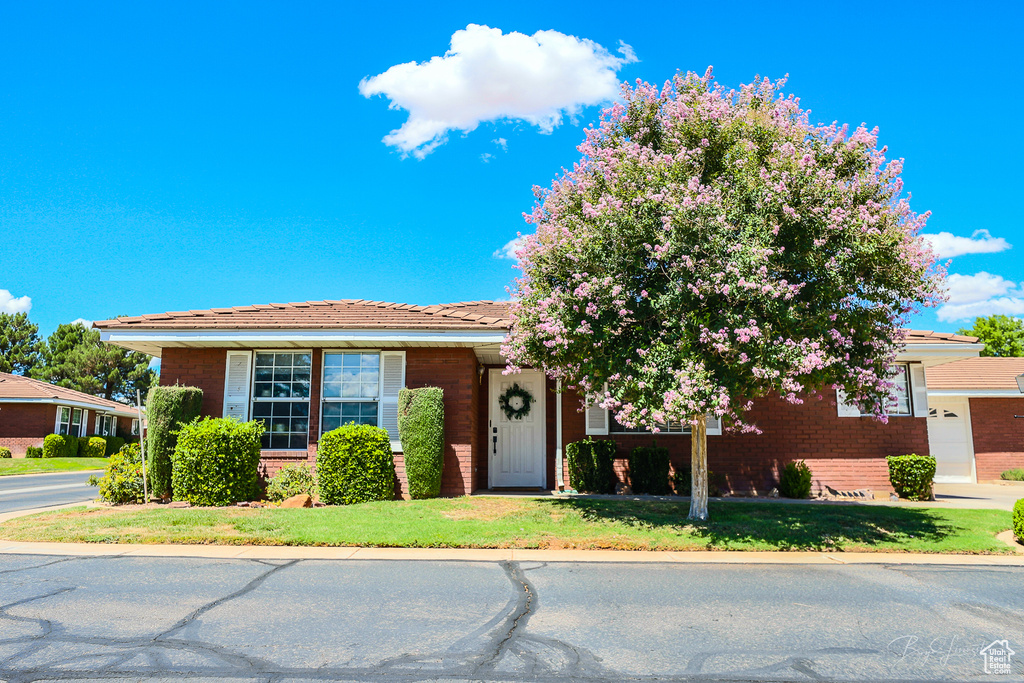 View of front facade with brick siding and a front yard