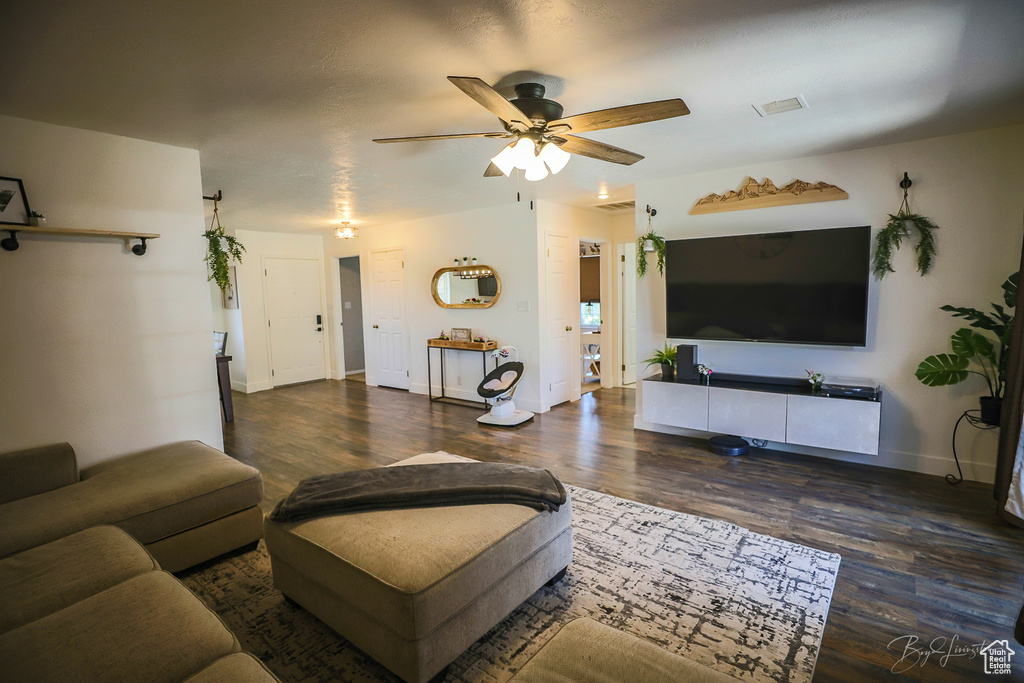 Living room featuring wood finished floors, visible vents, baseboards, and ceiling fan