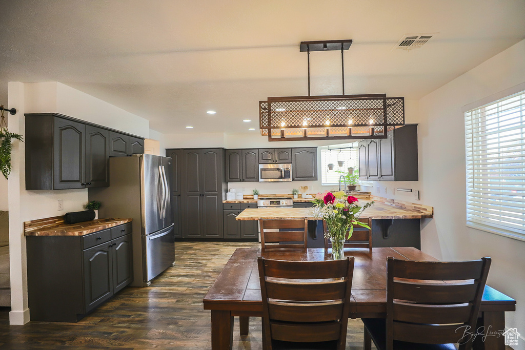 Kitchen featuring a peninsula, dark wood-style flooring, visible vents, recessed lighting, and appliances with stainless steel finishes