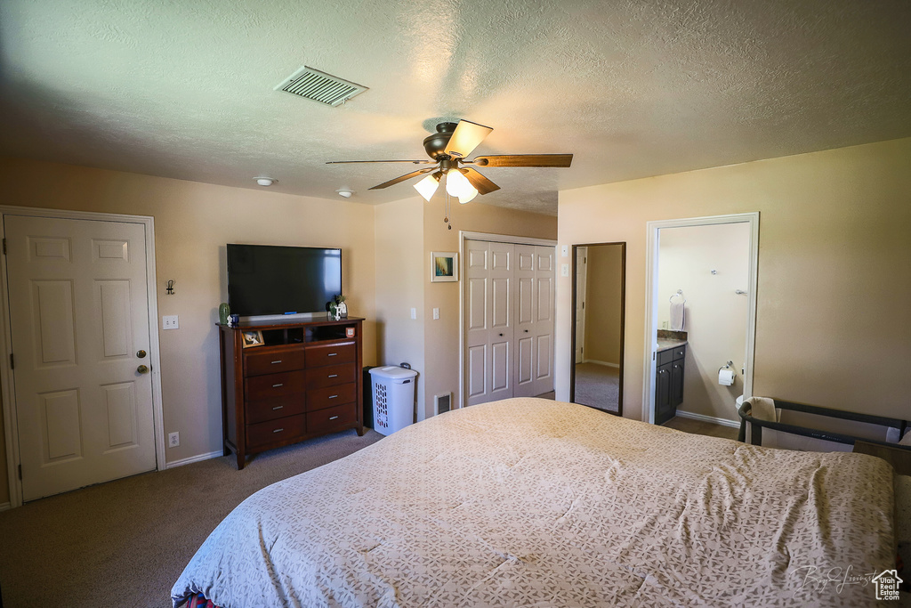 Carpeted bedroom featuring a textured ceiling, visible vents, baseboards, and ceiling fan