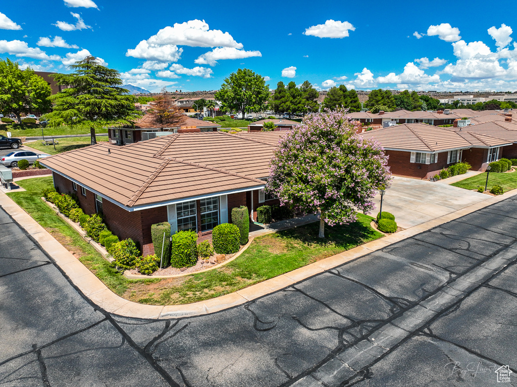 Exterior space featuring brick siding, a residential view, and a tile roof