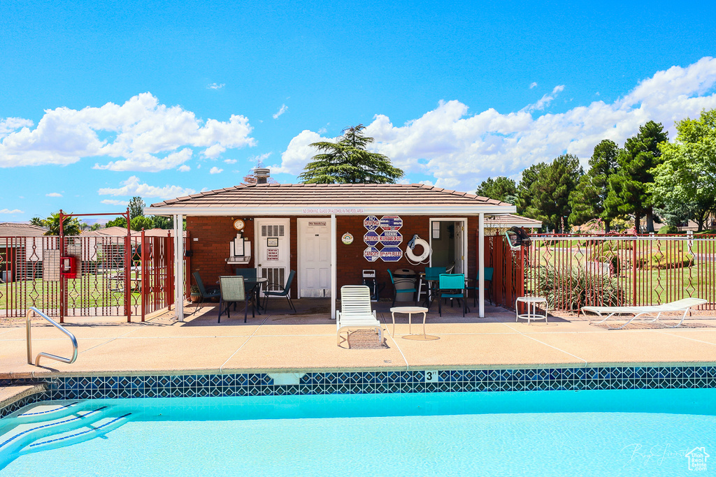 View of pool with fence, a patio area, a fenced in pool, and an outdoor structure