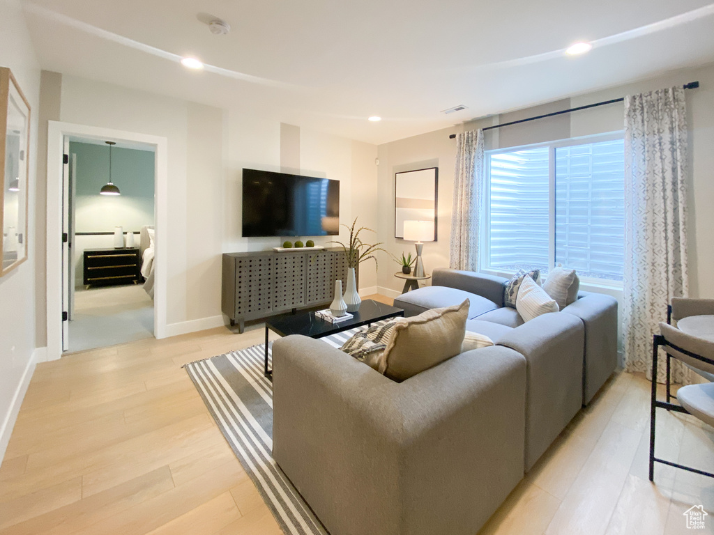 Living room with visible vents, light wood-style flooring, baseboards, and recessed lighting