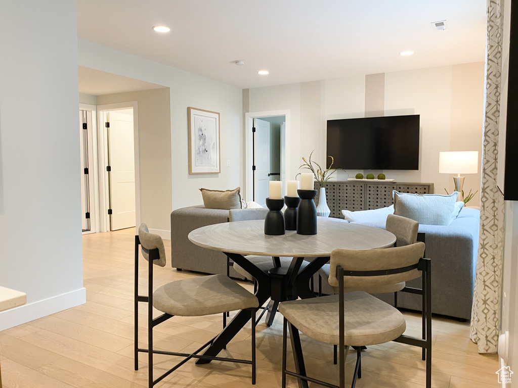 Dining room featuring light wood-type flooring, baseboards, visible vents, and recessed lighting