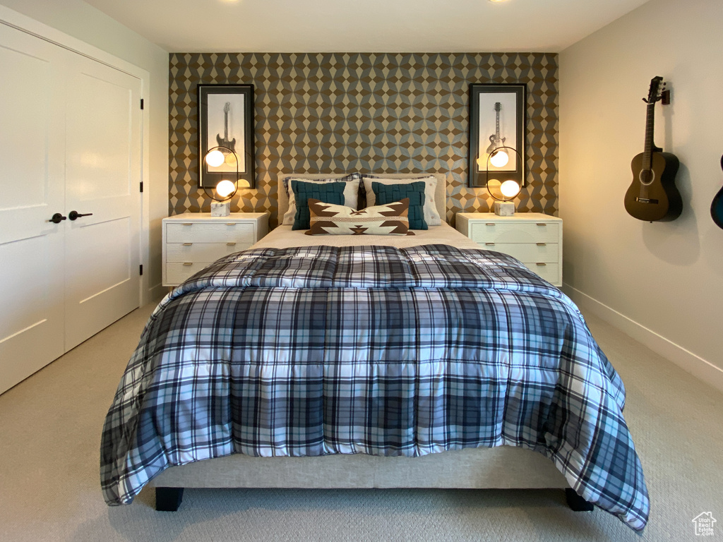 Carpeted bedroom with baseboards and wallpapered walls