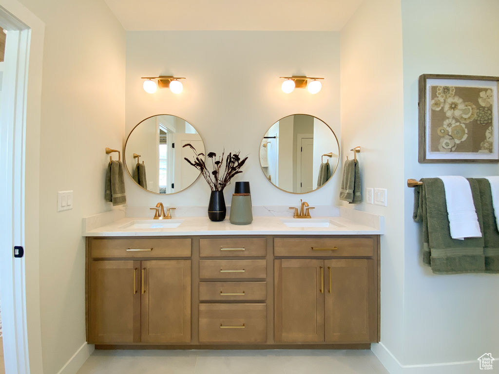Bathroom with double vanity, baseboards, and a sink