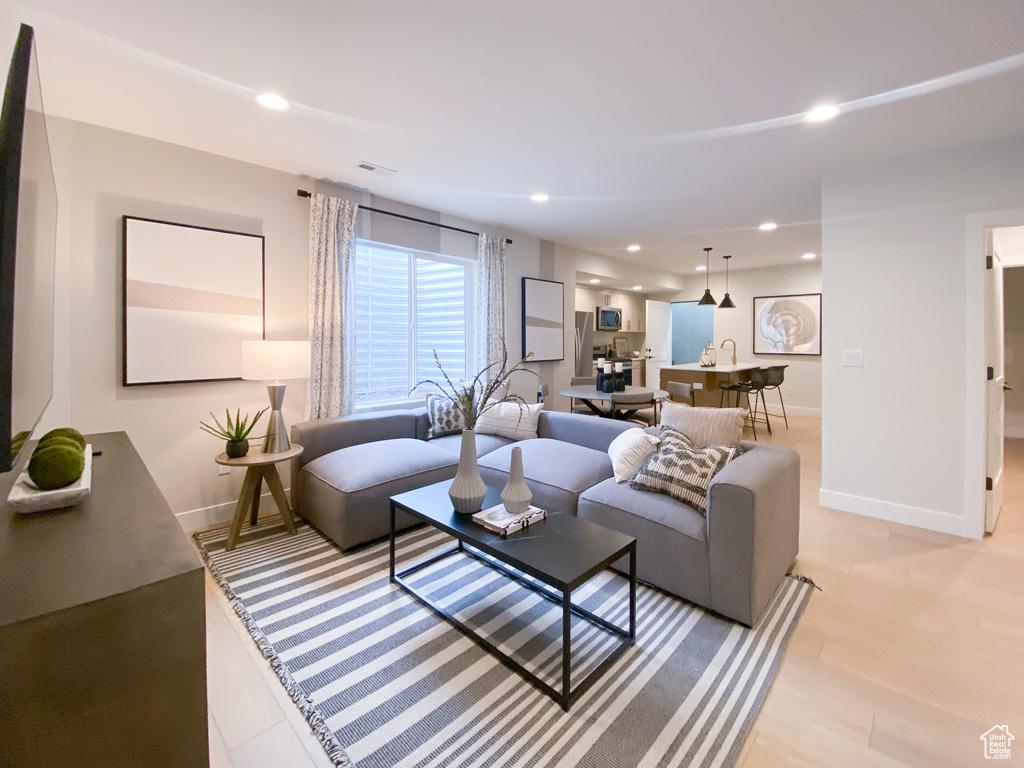 Living area with recessed lighting, visible vents, and baseboards