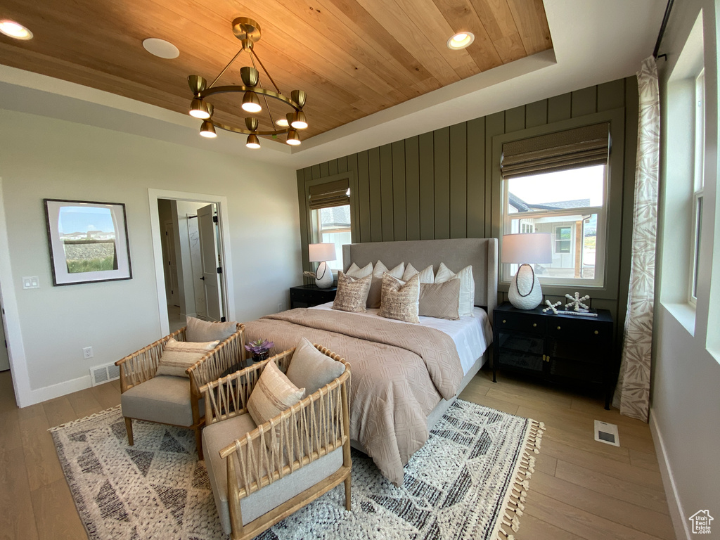 Bedroom with wood ceiling, a notable chandelier, light wood finished floors, and visible vents