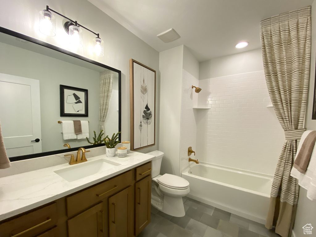 Bathroom featuring shower / bath combination, vanity, and toilet