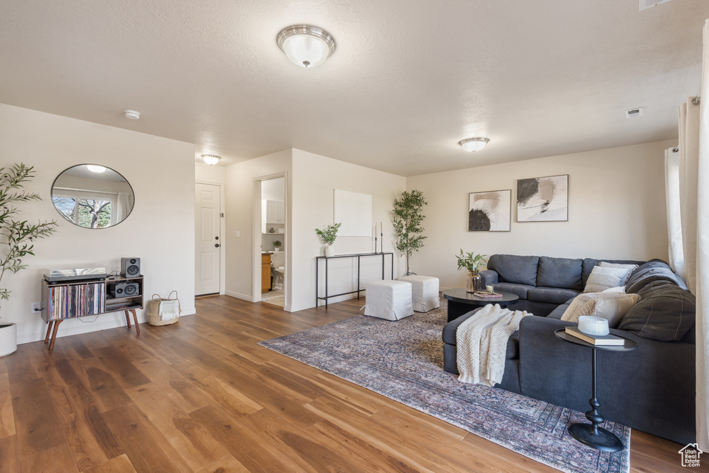 Living area with baseboards and wood finished floors