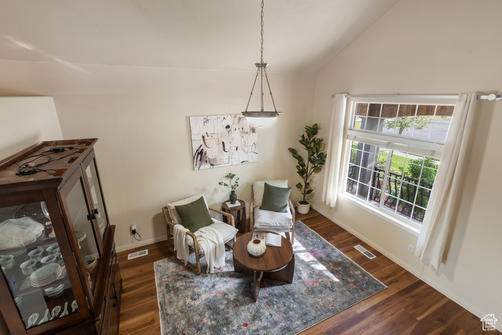 Sitting room featuring lofted ceiling, dark wood-type flooring, visible vents, and baseboards