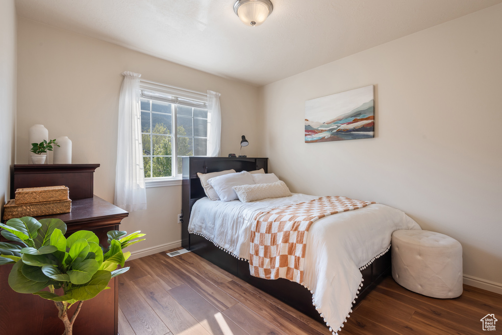 Bedroom featuring wood finished floors, visible vents, and baseboards