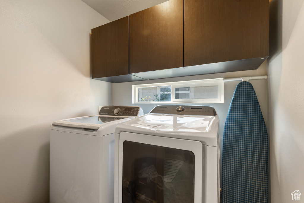 Laundry area with separate washer and dryer and cabinet space