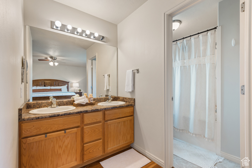 Full bathroom with a ceiling fan, a sink, double vanity, and ensuite bathroom