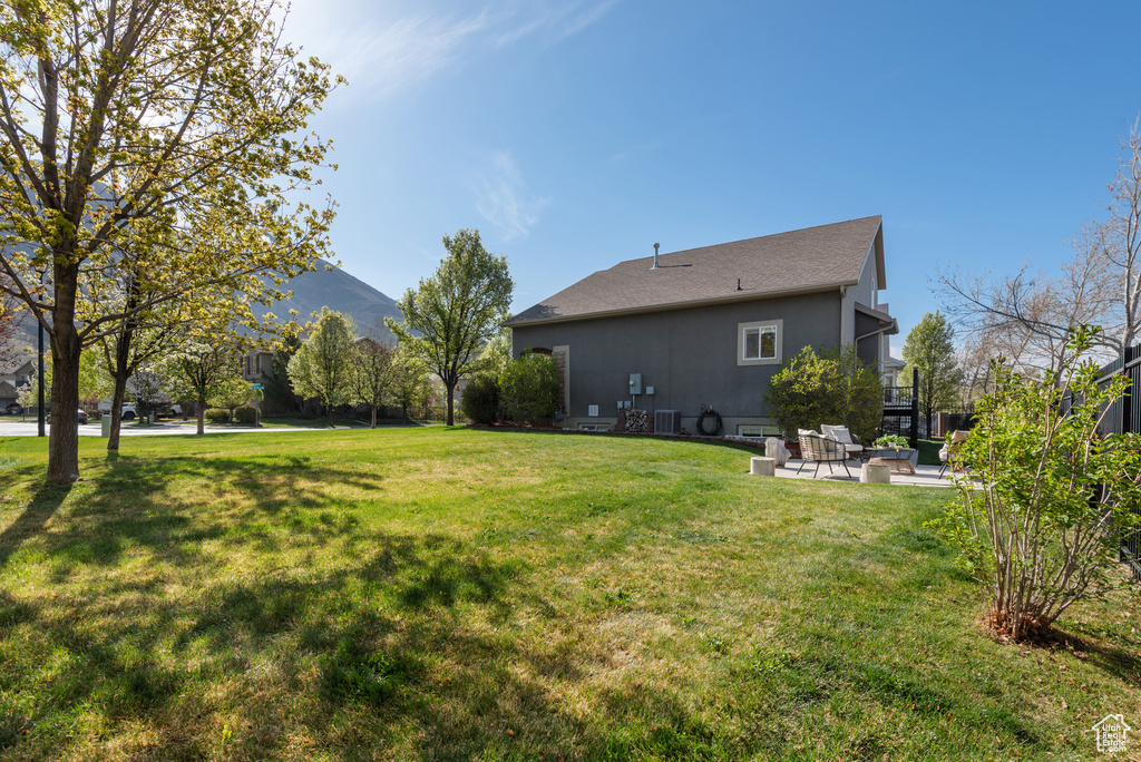 View of yard with central air condition unit and a patio area