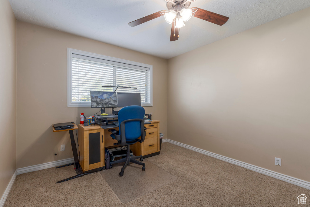 Office space featuring baseboards, light carpet, and ceiling fan