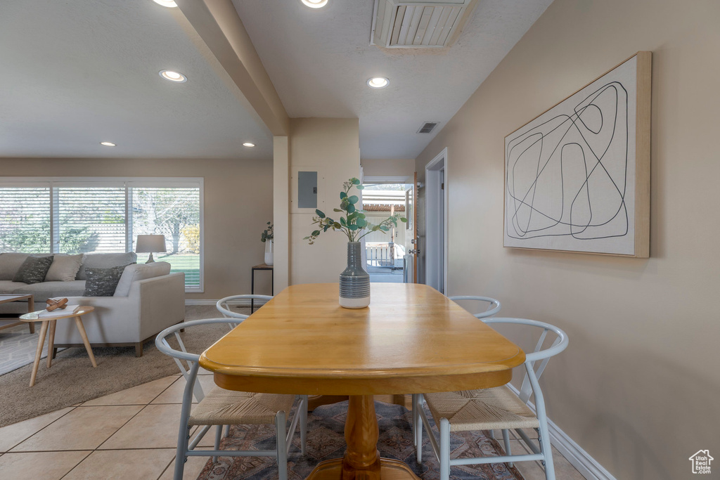Dining space with recessed lighting, healthy amount of natural light, baseboards, light tile patterned flooring, and light colored carpet