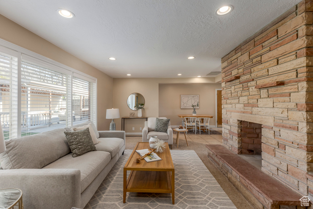 Tiled living room with recessed lighting, a textured ceiling, and baseboards
