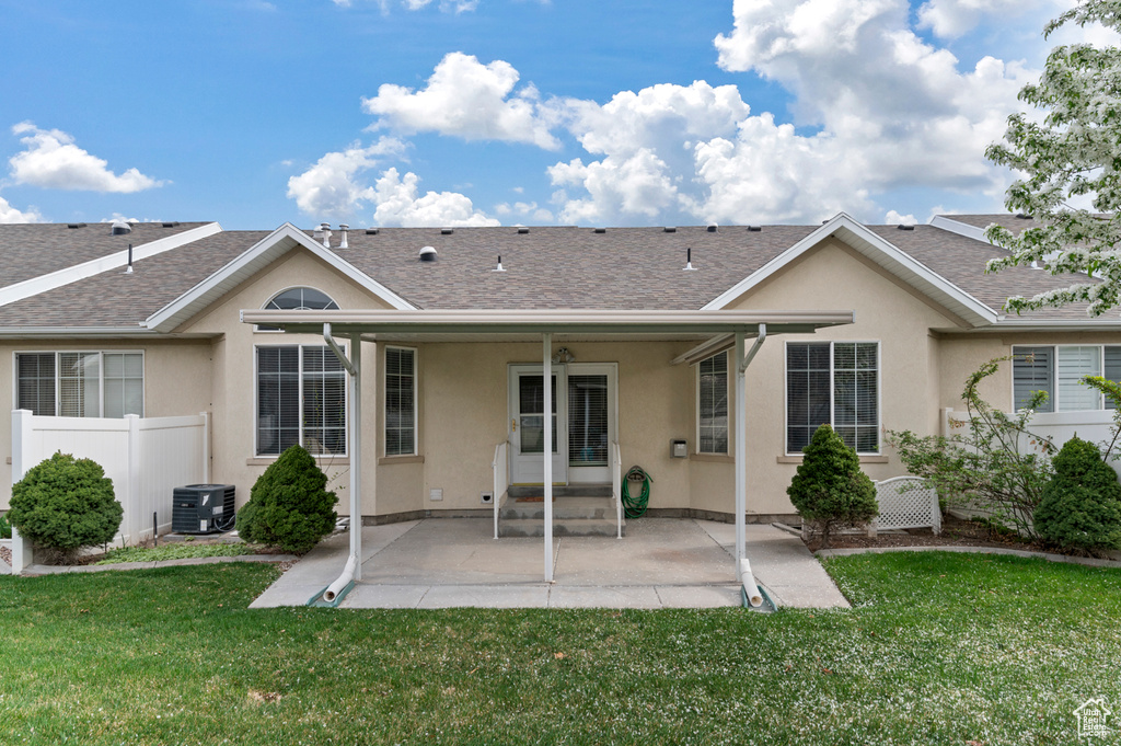 Back of house featuring fence, a patio area, a shingled roof, and stucco siding