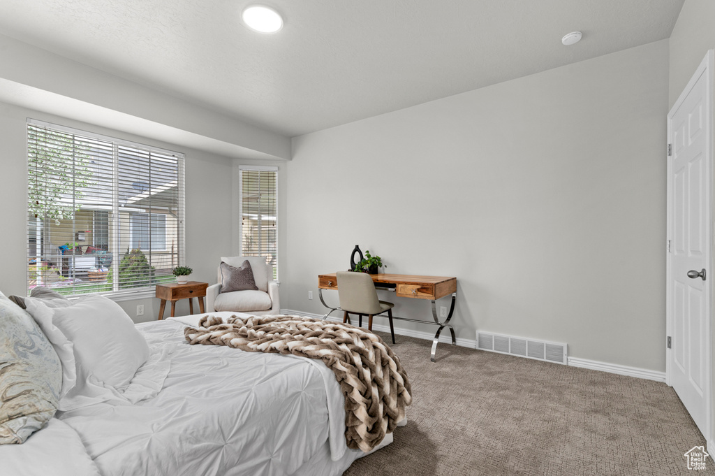 Bedroom with carpet floors, visible vents, and baseboards