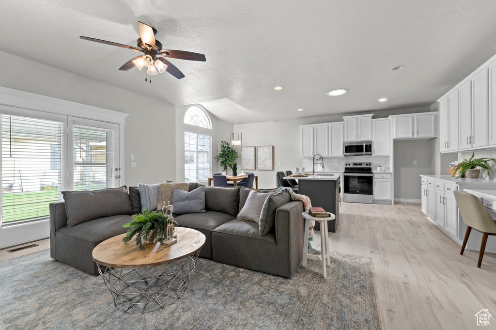 Living room featuring a ceiling fan, light wood-style floors, visible vents, and recessed lighting