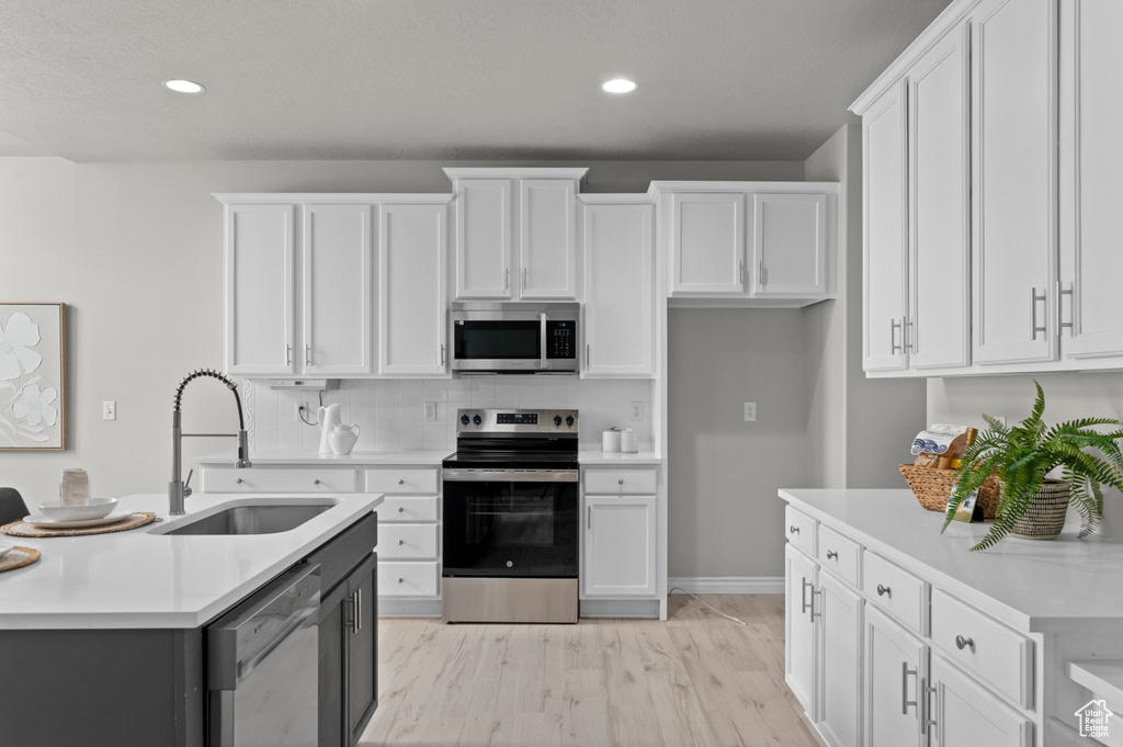 Kitchen with white cabinets, stainless steel appliances, and a sink