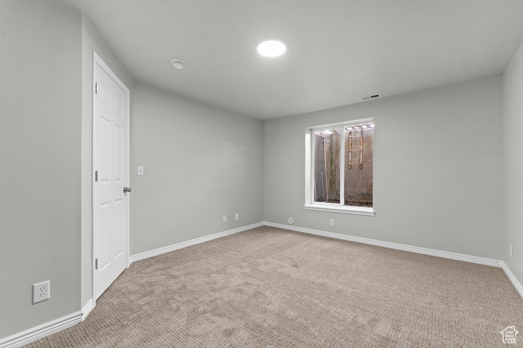 Carpeted empty room featuring baseboards and visible vents