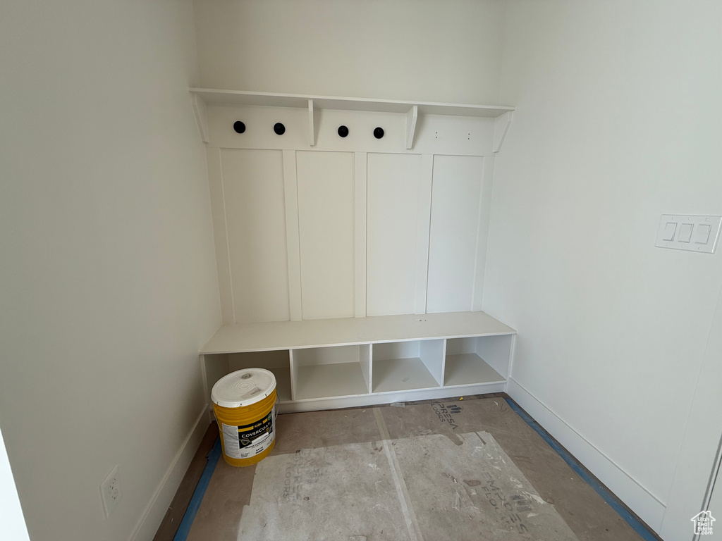 Mudroom featuring baseboards and unfinished concrete flooring