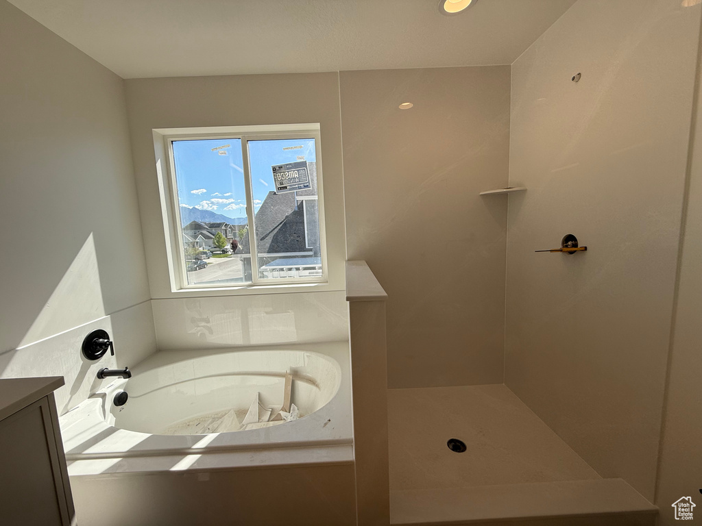 Bathroom featuring a garden tub and a shower