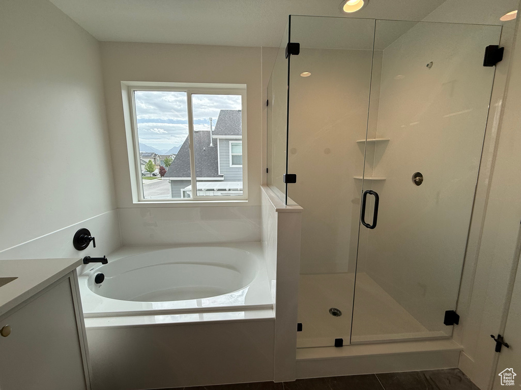 Full bath with a stall shower, a bath, and vanity