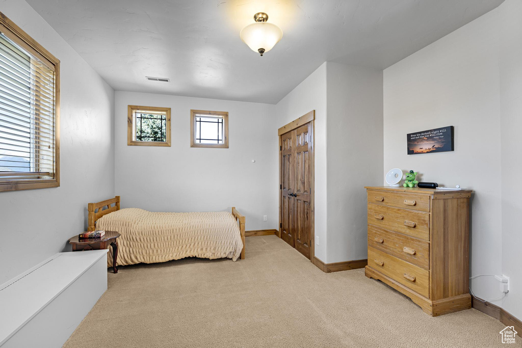 Bedroom featuring light carpet, baseboards, and visible vents