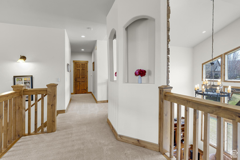 Hall with baseboards, a chandelier, recessed lighting, an upstairs landing, and light colored carpet