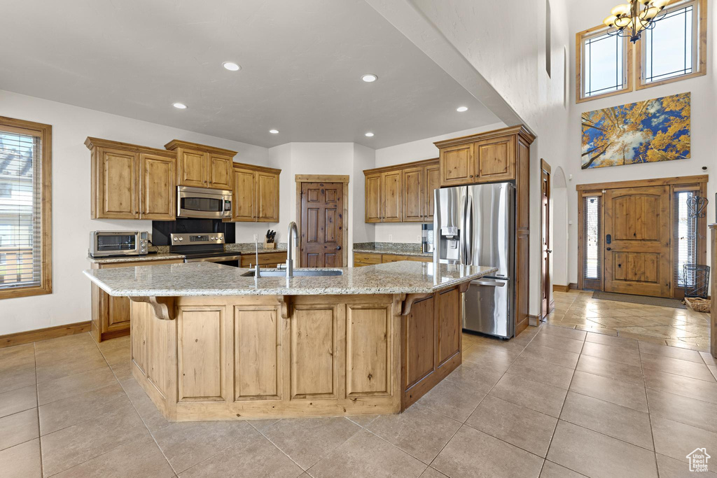 Kitchen featuring baseboards, a sink, a kitchen breakfast bar, recessed lighting, and stainless steel appliances