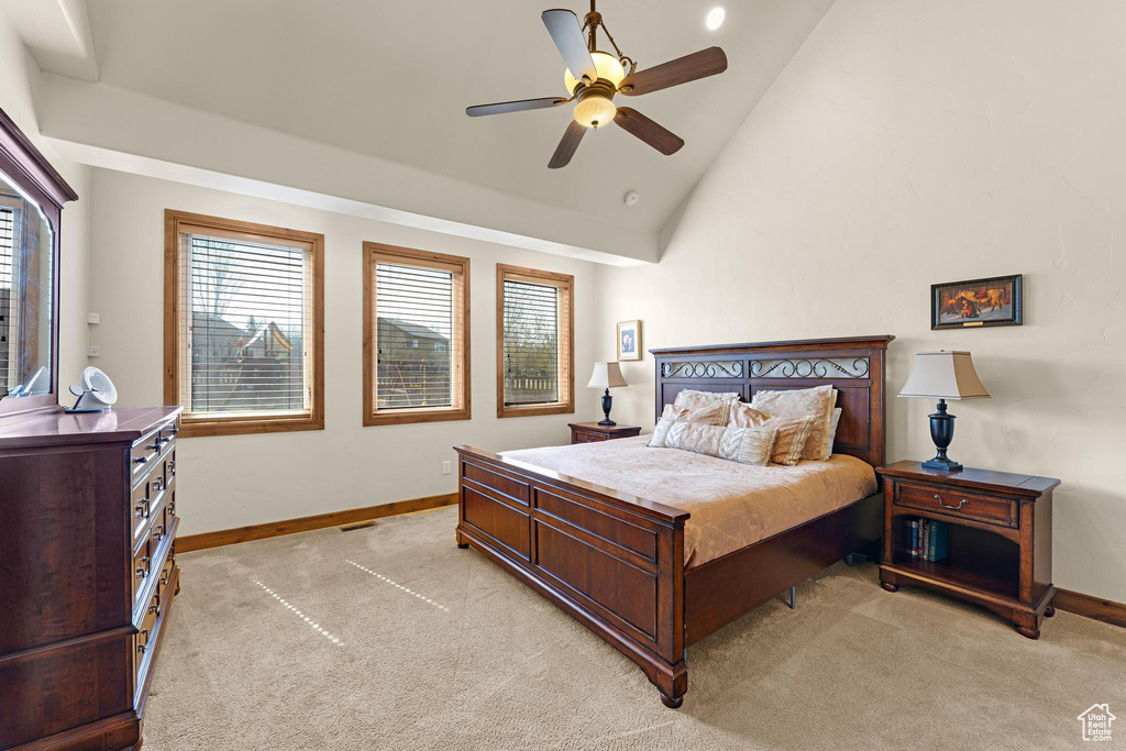 Bedroom featuring baseboards, ceiling fan, light colored carpet, and vaulted ceiling