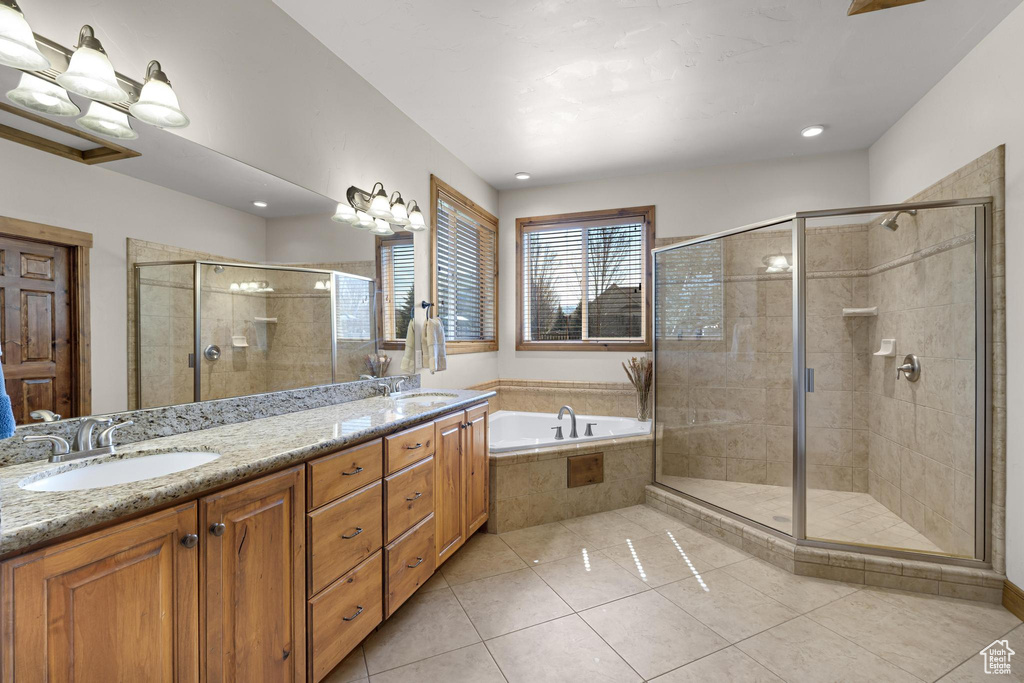 Full bathroom featuring a shower stall, tile patterned floors, a bath, and a sink