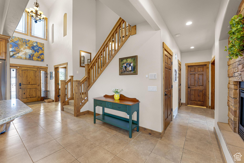 Entryway featuring recessed lighting, a notable chandelier, light tile patterned floors, and stairs