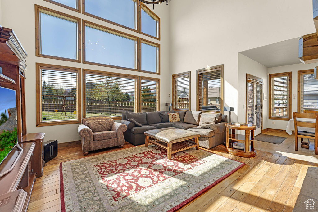 Living room featuring light wood-style floors and a high ceiling