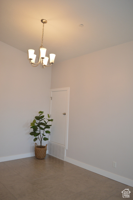 Interior space with a notable chandelier, visible vents, and baseboards