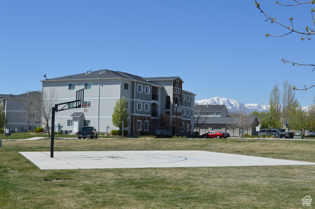 View of basketball court with community basketball court, a mountain view, and a lawn