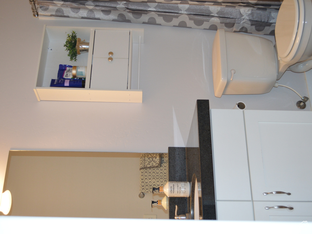 Full bathroom featuring toilet, a shower with shower curtain, vanity, and baseboards