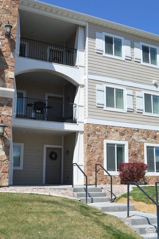 View of front of home with a front yard and stone siding