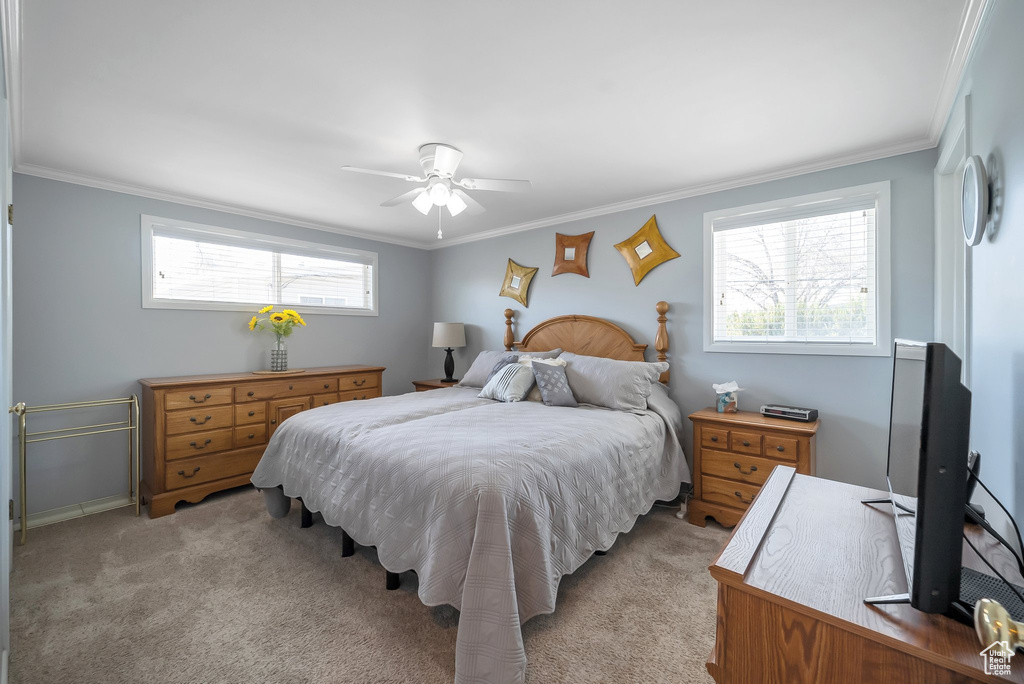 Bedroom with light carpet, baseboards, ornamental molding, and ceiling fan